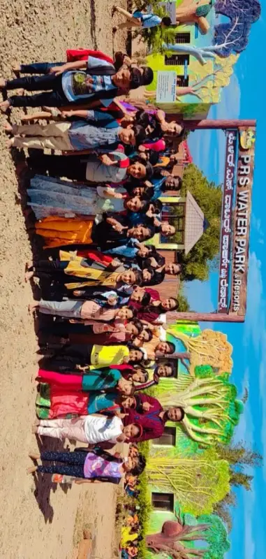 A group of children and adults pose outdoors beside a sign that reads P.R.S Water Park and Resorts.